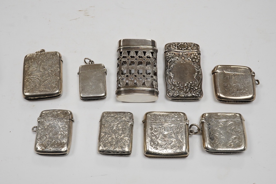 Seven assorted late 19th/early 20th century silver vesta cases, largest 48mm, a sterling case and one other pierced white metal case. Condition - poor to fair